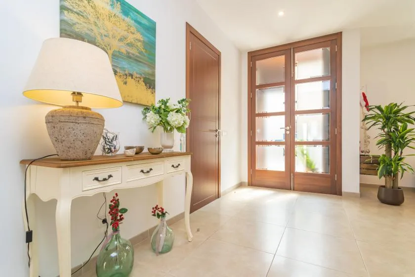 A bright entryway with a console table and a glazed wooden door.