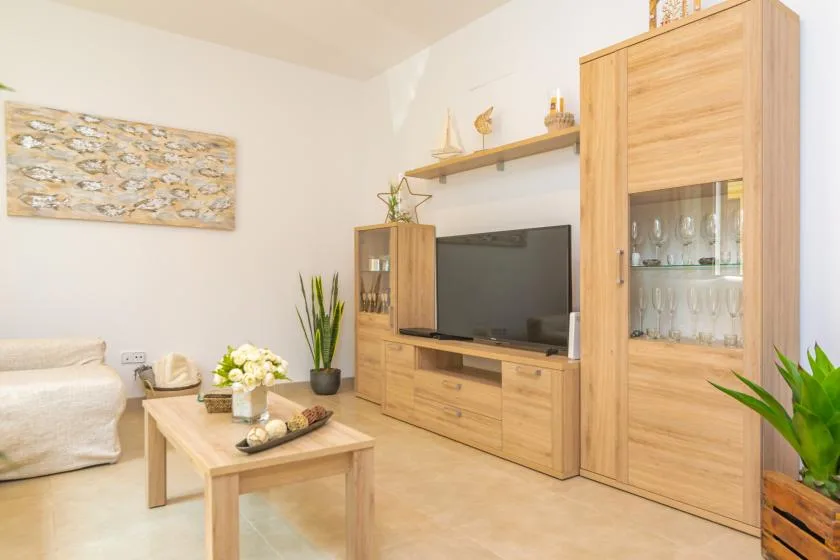 A bright living room with wooden cabinets, a television, and a coffee table.