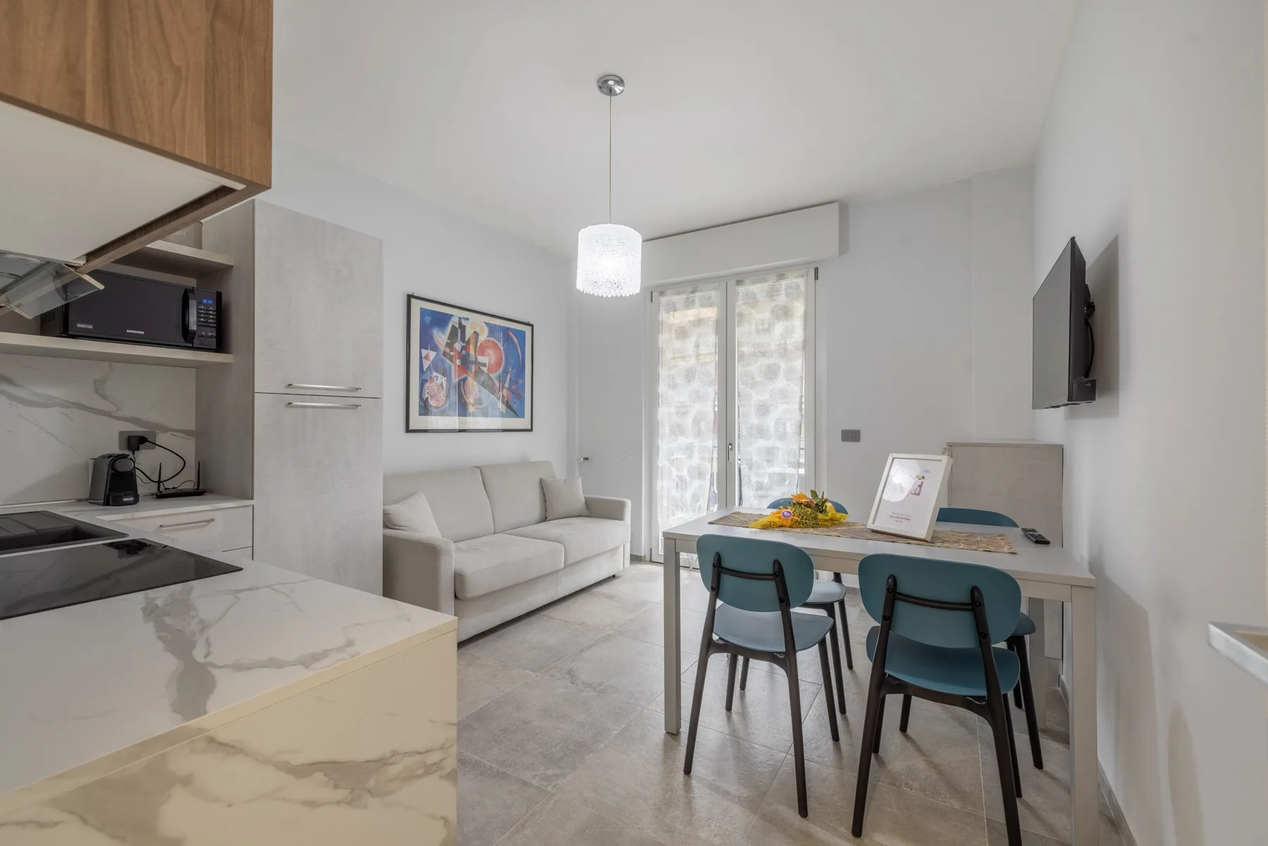 Una cocina y comedor luminosos de concepto abierto, con asientos junto a grandes ventanas.