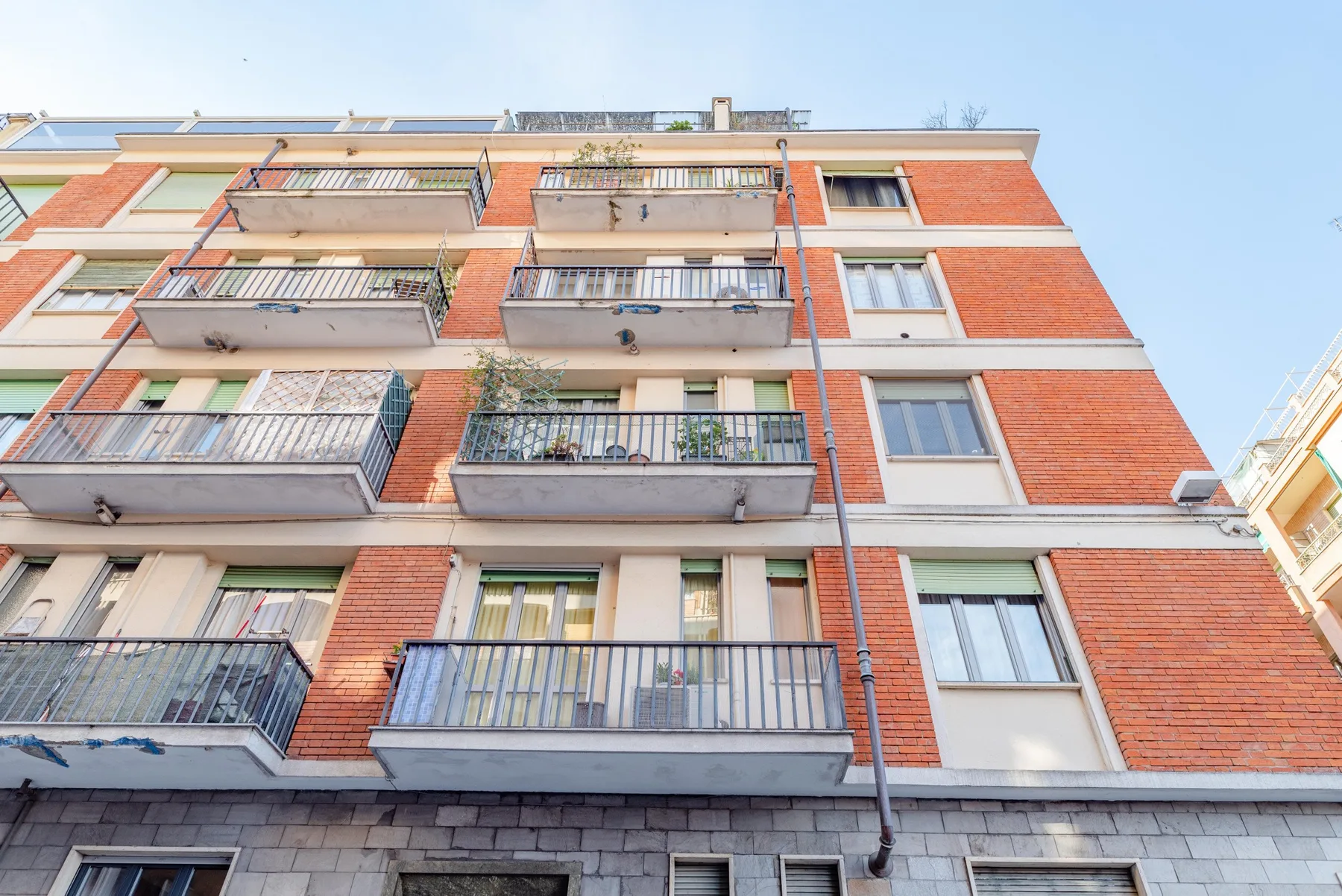 A red-brick apartment building with balconies and rows of windows.