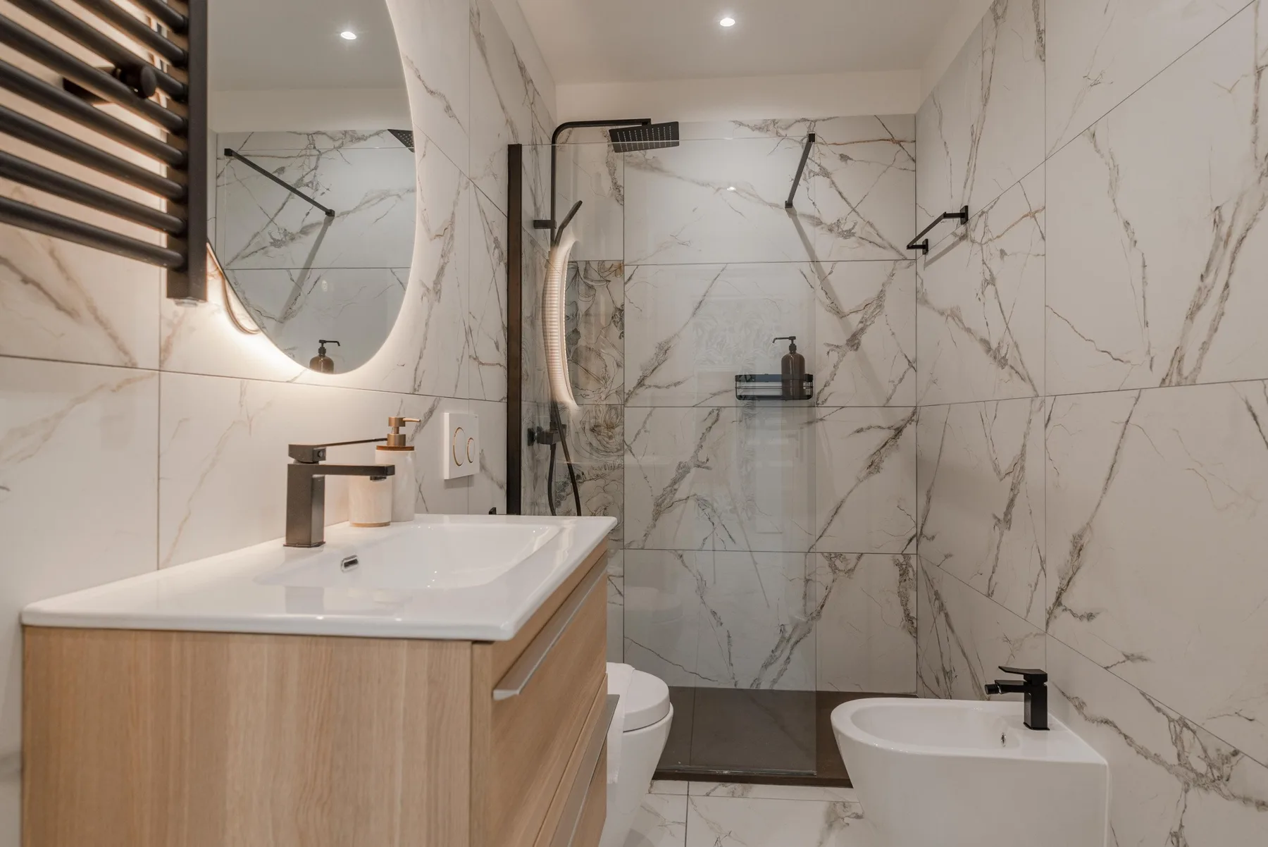 A modern bathroom with a vanity, mirror, shower, and bathtub.