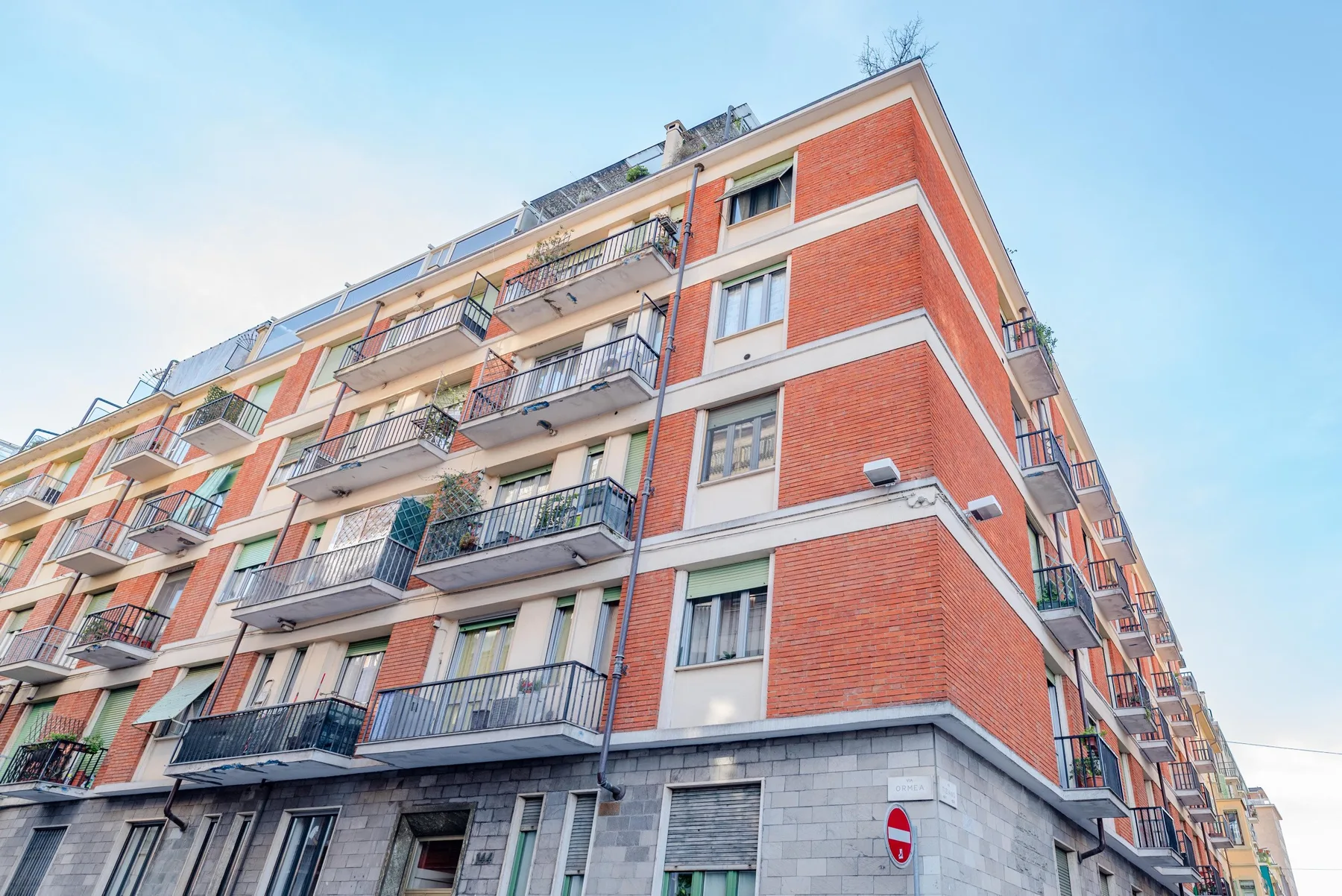 Apartment building exterior with red brick walls and balconies.
