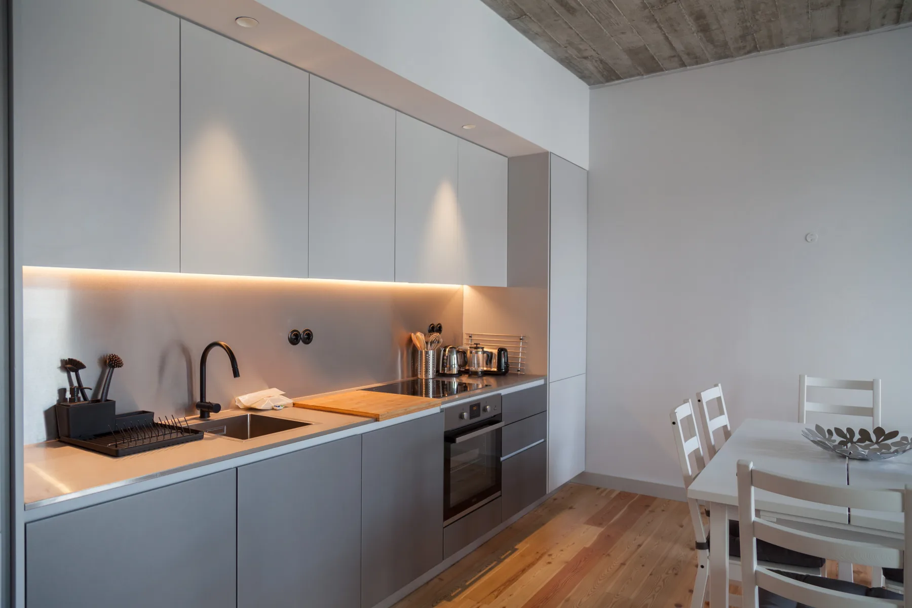 Cocina y comedor modernos con una encimera larga y una mesa.