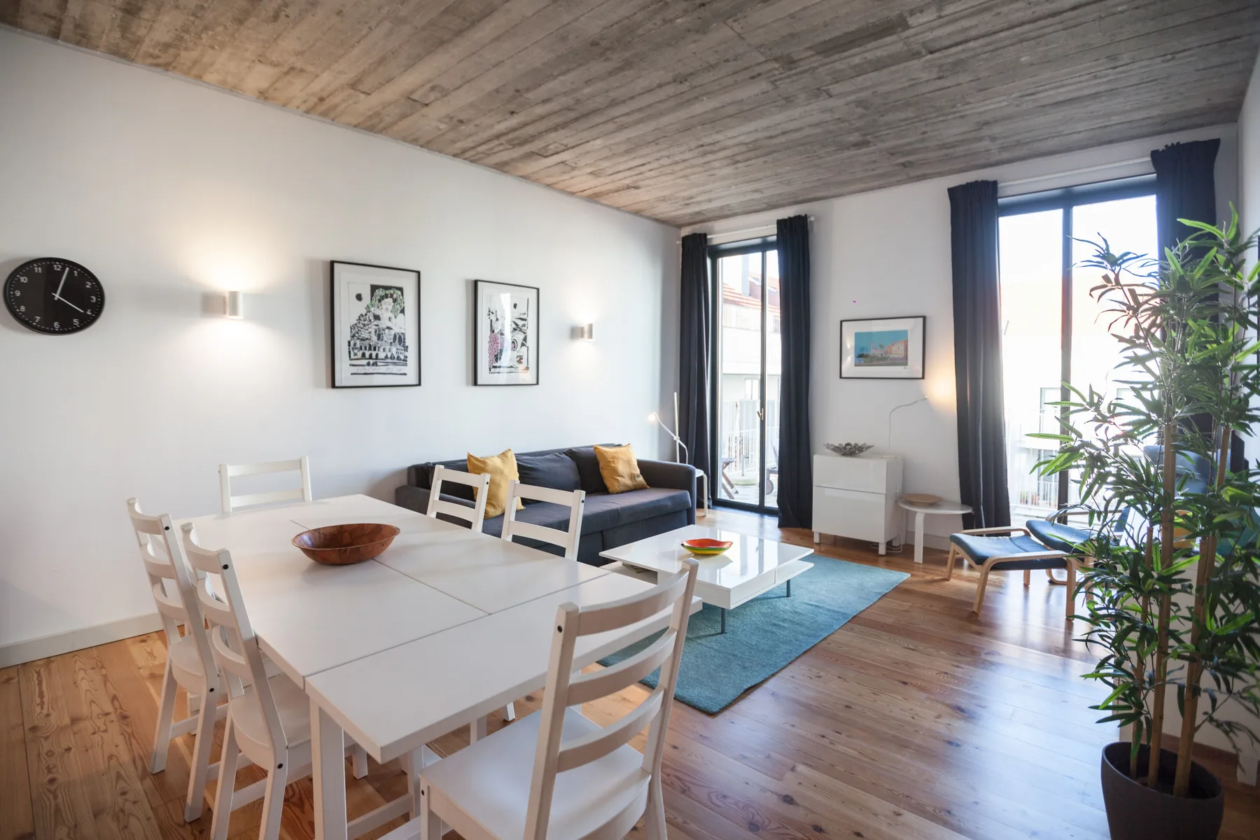 Una luminosa sala de estar y comedor con una mesa blanca y asientos.