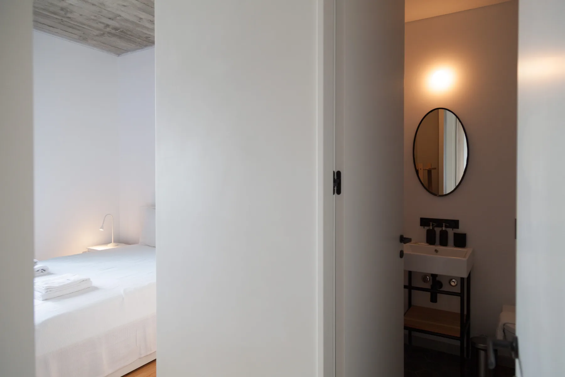 Se ven un dormitorio y un baño a través de una puerta abierta.