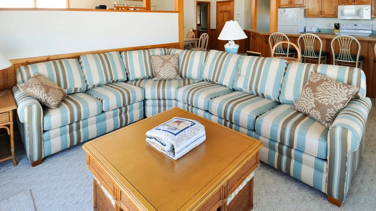 Una sala de estar con asientos a rayas y una mesa de centro de madera.