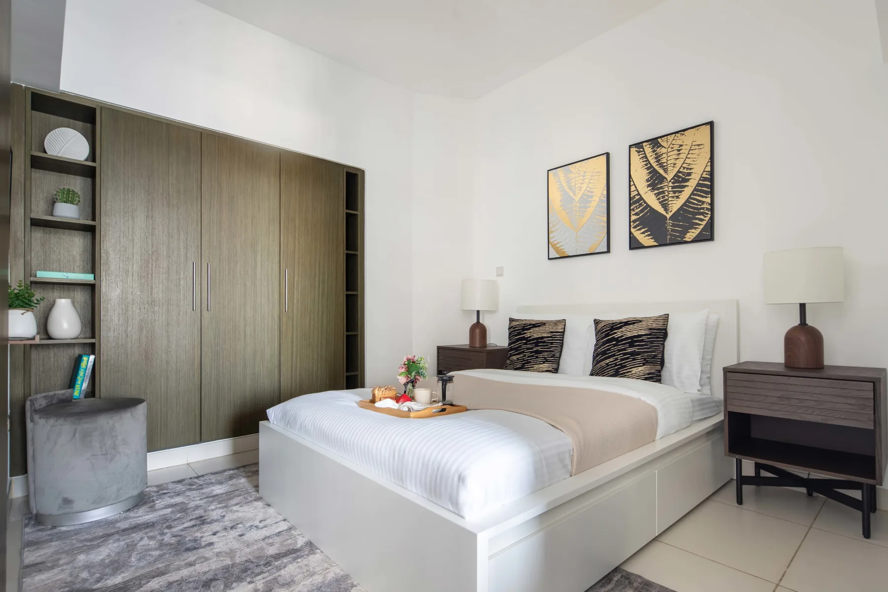 Un dormitorio luminoso con una cama bien arreglada y armarios empotrados.