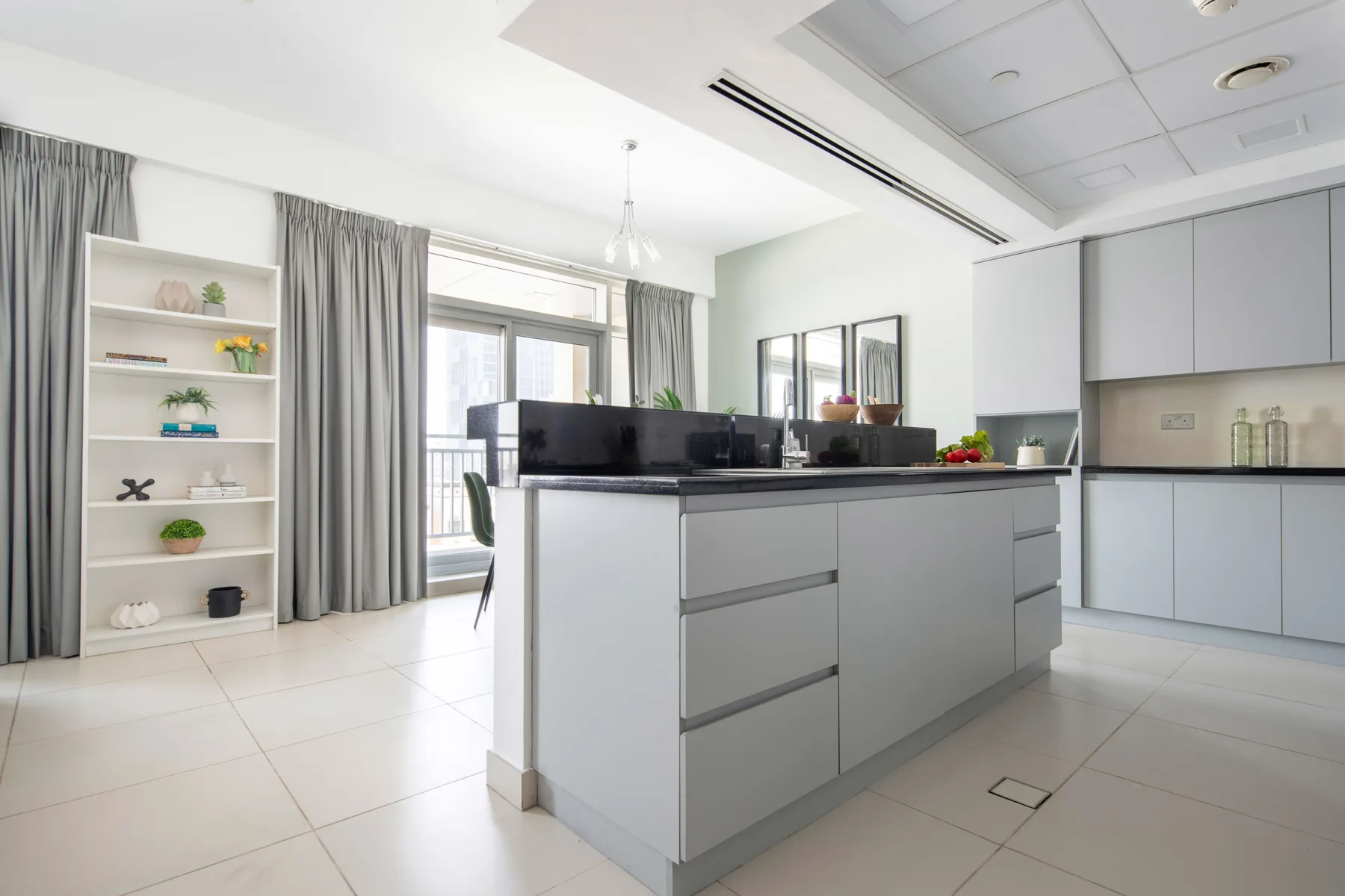Una cocina luminosa con una isla central y ventanas grandes.