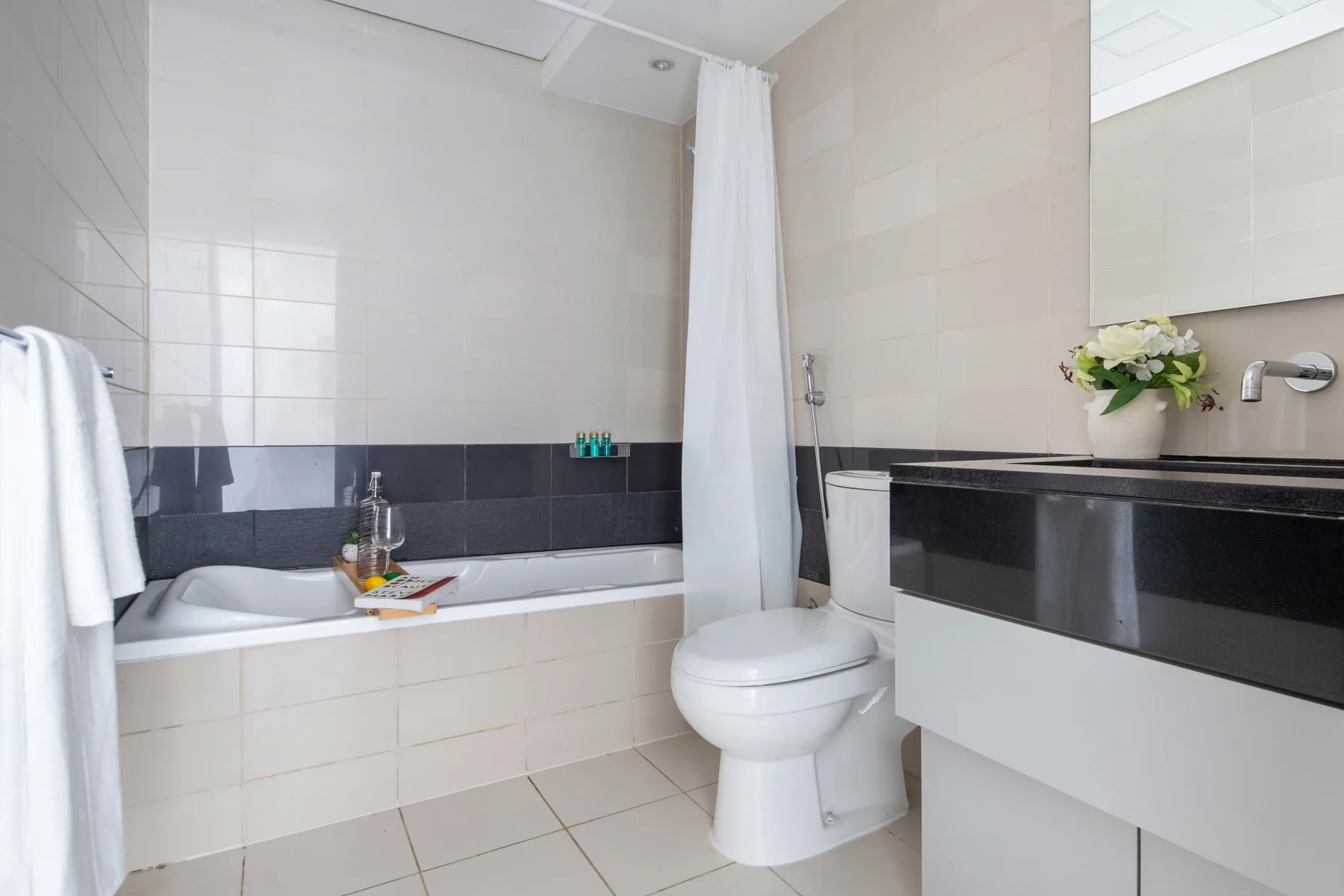 Un baño alicatado con bañera, inodoro y lavabo.
