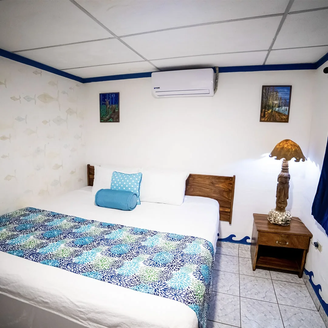 Cama en una habitación con decoración tropical.