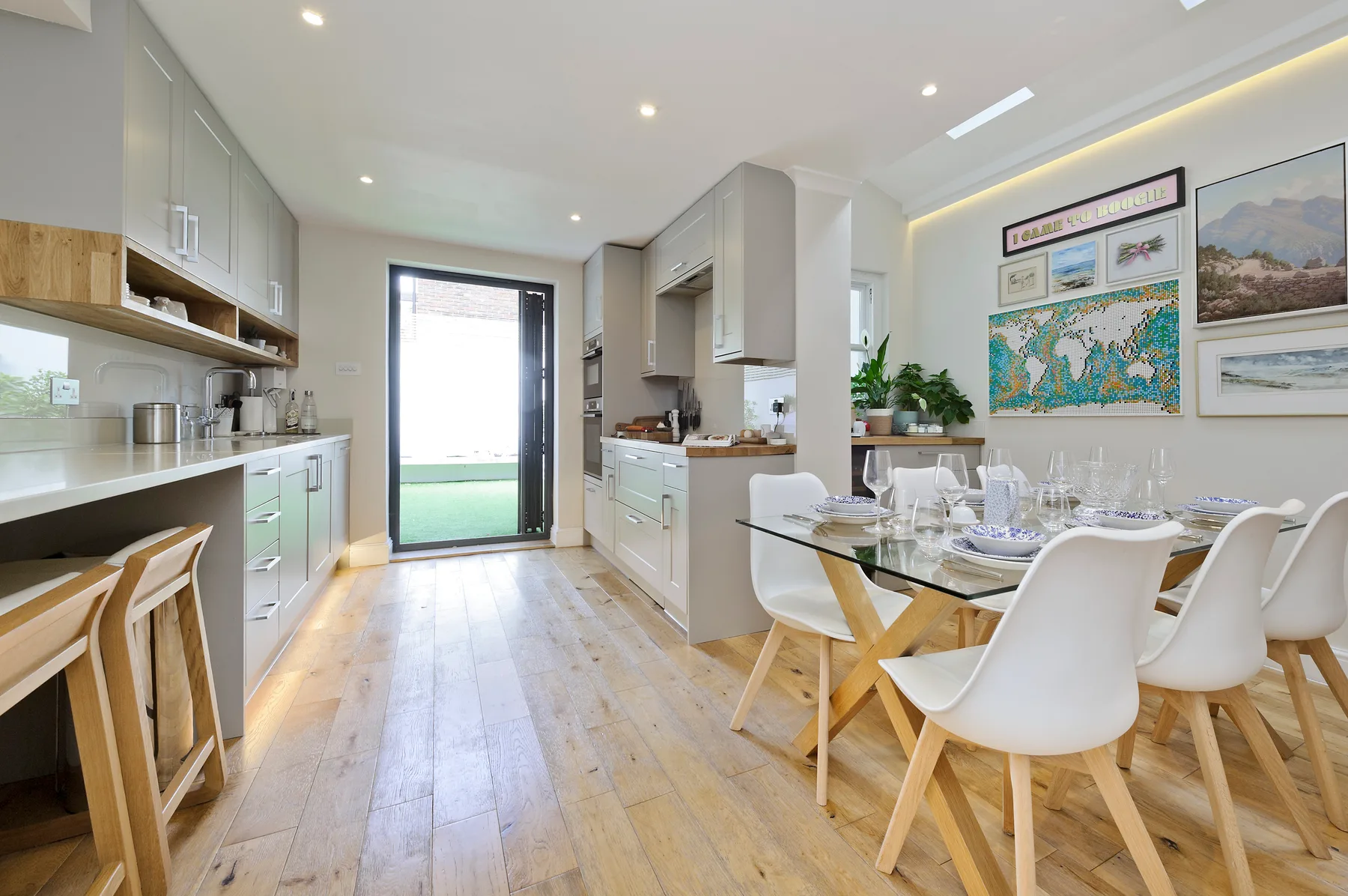 A bright kitchen and dining area with a table set beside the kitchen.