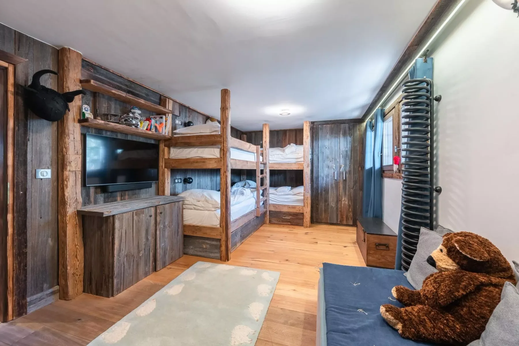 Un dormitorio revestido de madera con literas y un televisor.