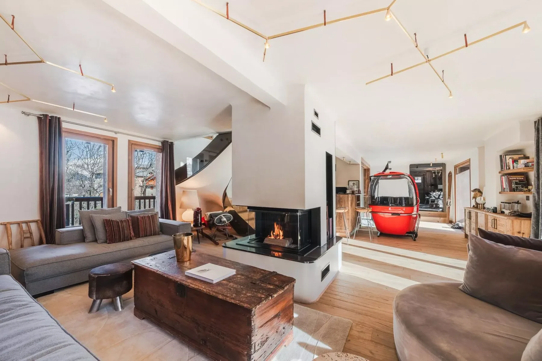 Una luminosa sala de estar abierta con asientos y una chimenea junto a la cocina.