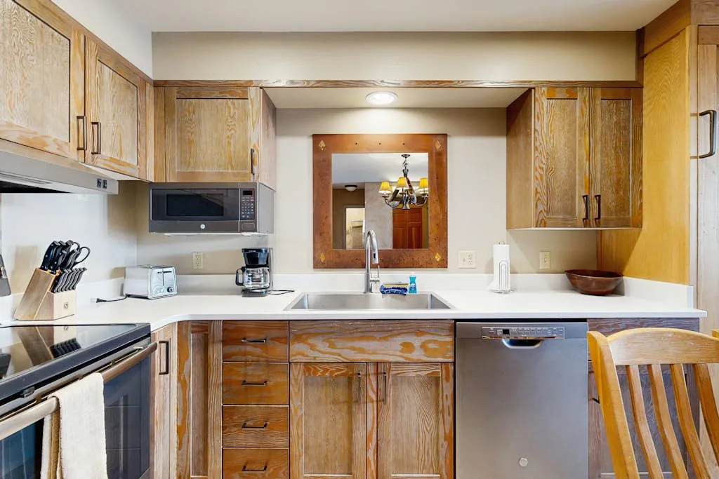 A kitchen with wood cabinetry, a countertop, and stainless steel appliances.