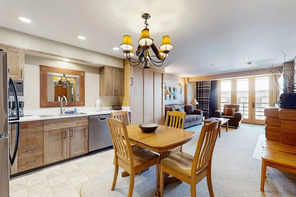 An open-plan living and dining area with a wooden dining table and kitchen.