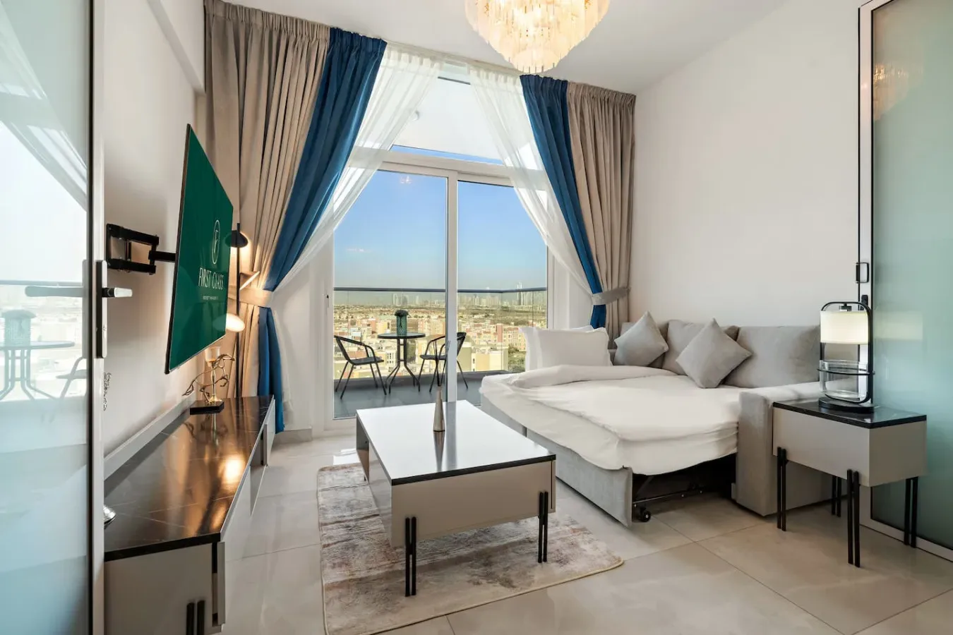 Una sala luminosa con un sofá seccional blanco y grandes ventanas con vista al balcón.