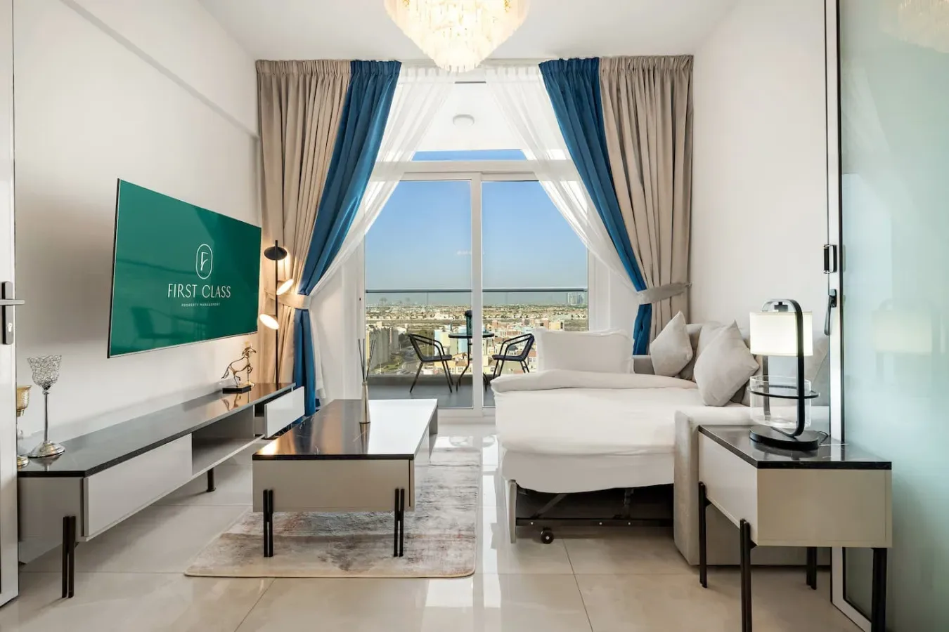 Una sala luminosa con televisor, asientos y grandes ventanas con vista a la ciudad.
