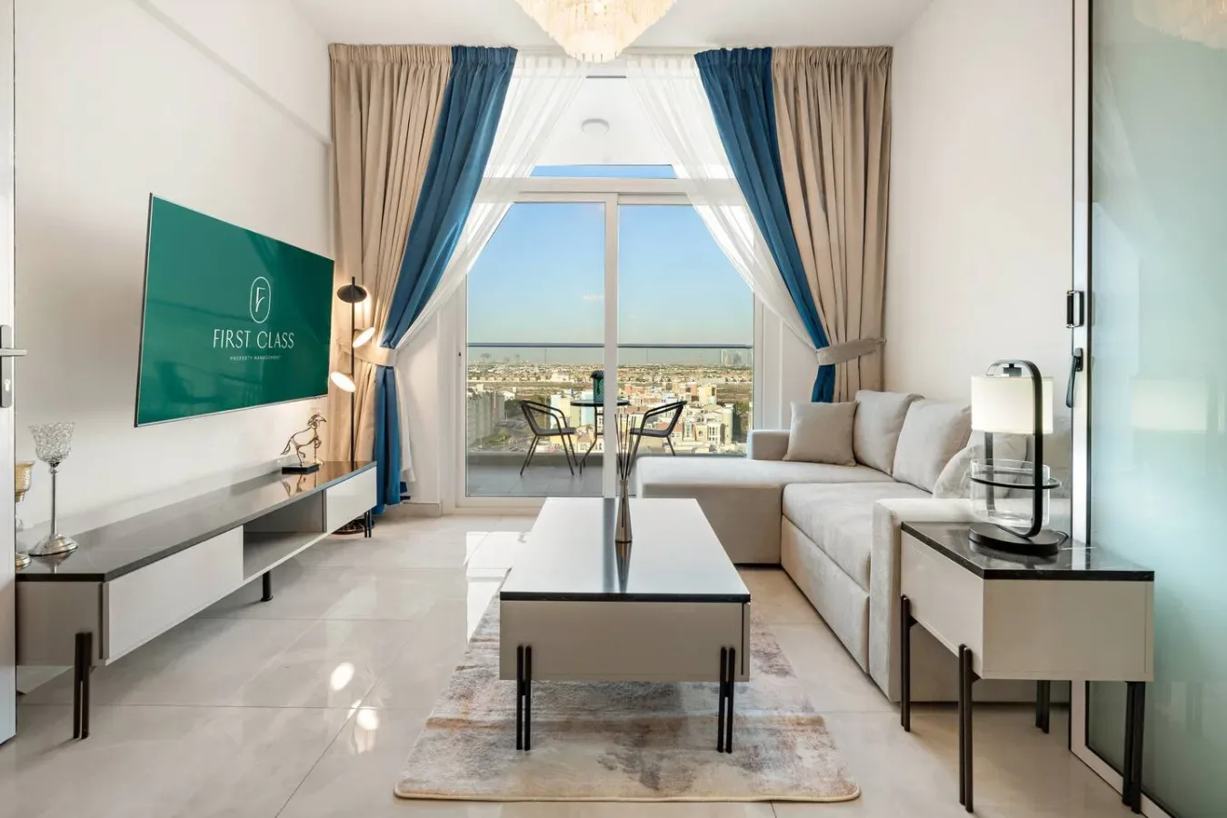 Una sala luminosa con asientos, una mesa de centro y grandes ventanas con vistas a la ciudad.