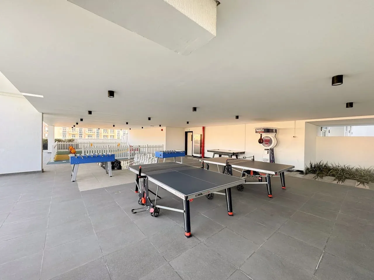 Una zona recreativa cubierta con varias mesas de tenis de mesa.