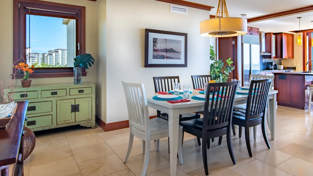 A dining area with a table and chairs beside a large window.