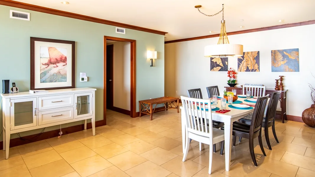 A dining room with a long table set with dishes and chairs.