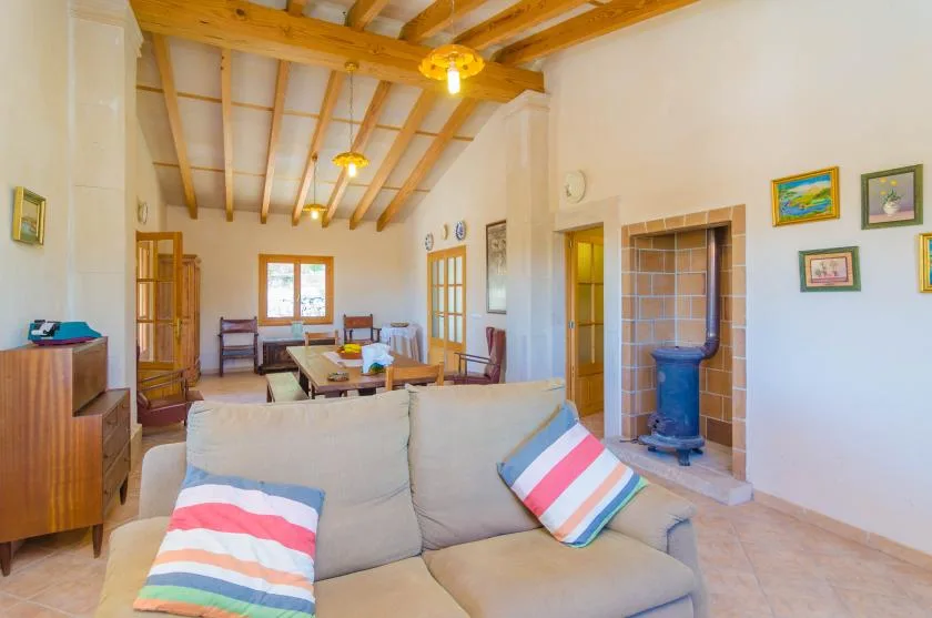 Una sala de estar con asientos, una mesa de comedor y una chimenea revestida de azulejos.