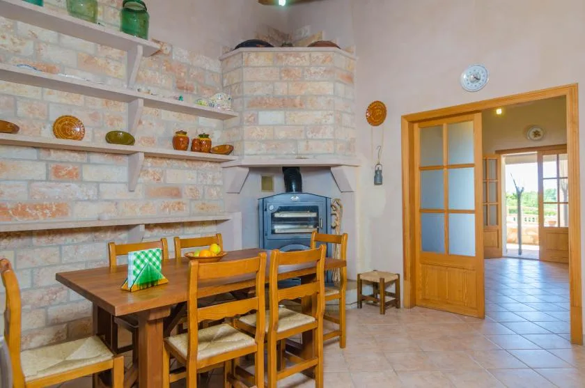 Una cocina rústica con una mesa de comedor de madera y un horno empotrado.