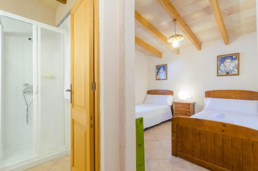 Un dormitorio con dos camas y un armario de madera junto a la ducha.