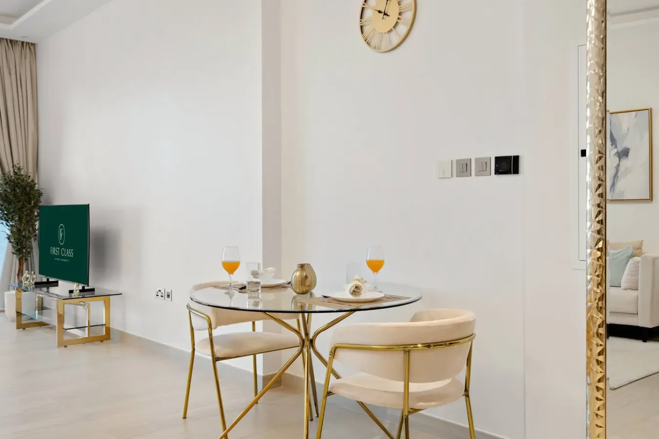 Una luminosa zona de estar y comedor con una mesa redonda y un televisor.