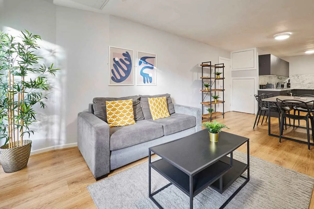 A living room with a gray sofa and a dining area.