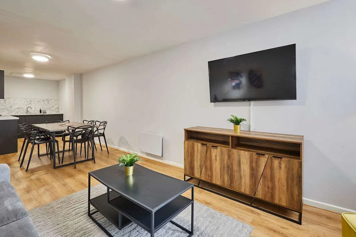 A living and dining area with a wall-mounted television and a dining table.
