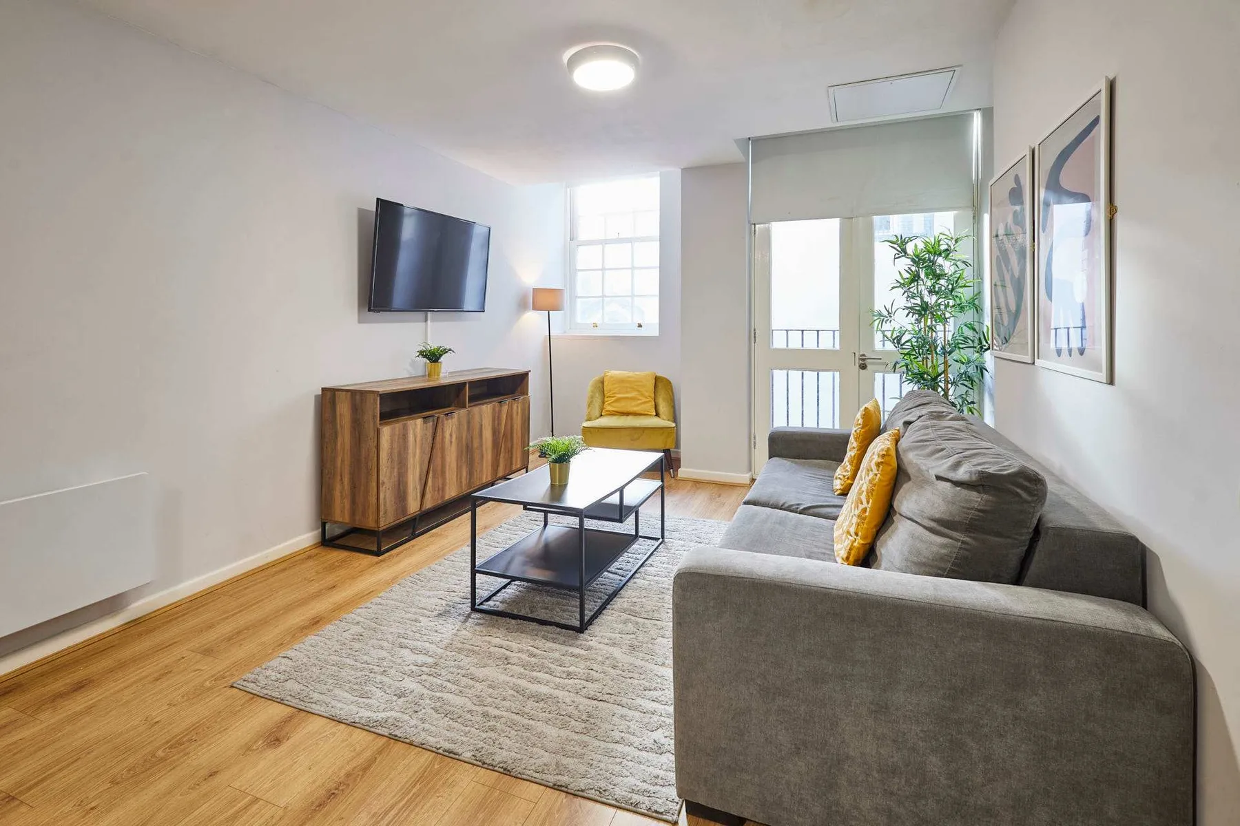 A living room with seating, a coffee table, and a television.