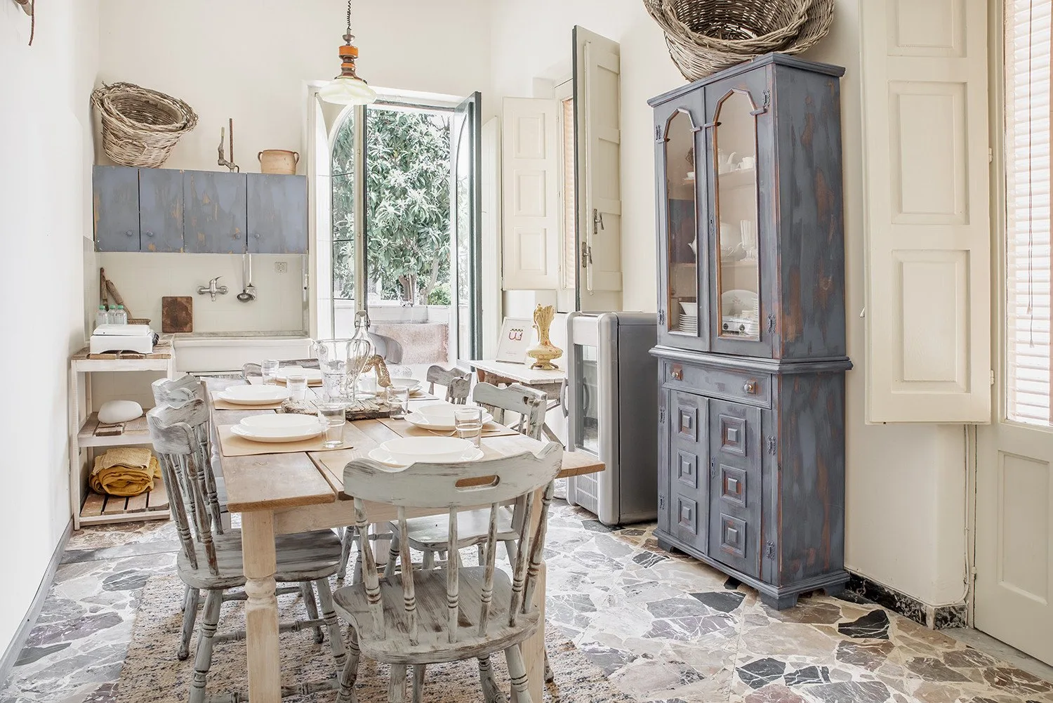 Un comedor luminoso con una mesa larga y un armario alto.