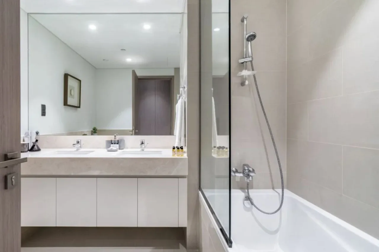 Un baño con bañera, ducha y tocador con lavabo.