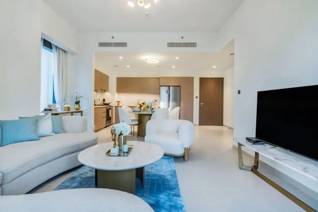 Una sala de estar y cocina de concepto abierto con asientos y un televisor.