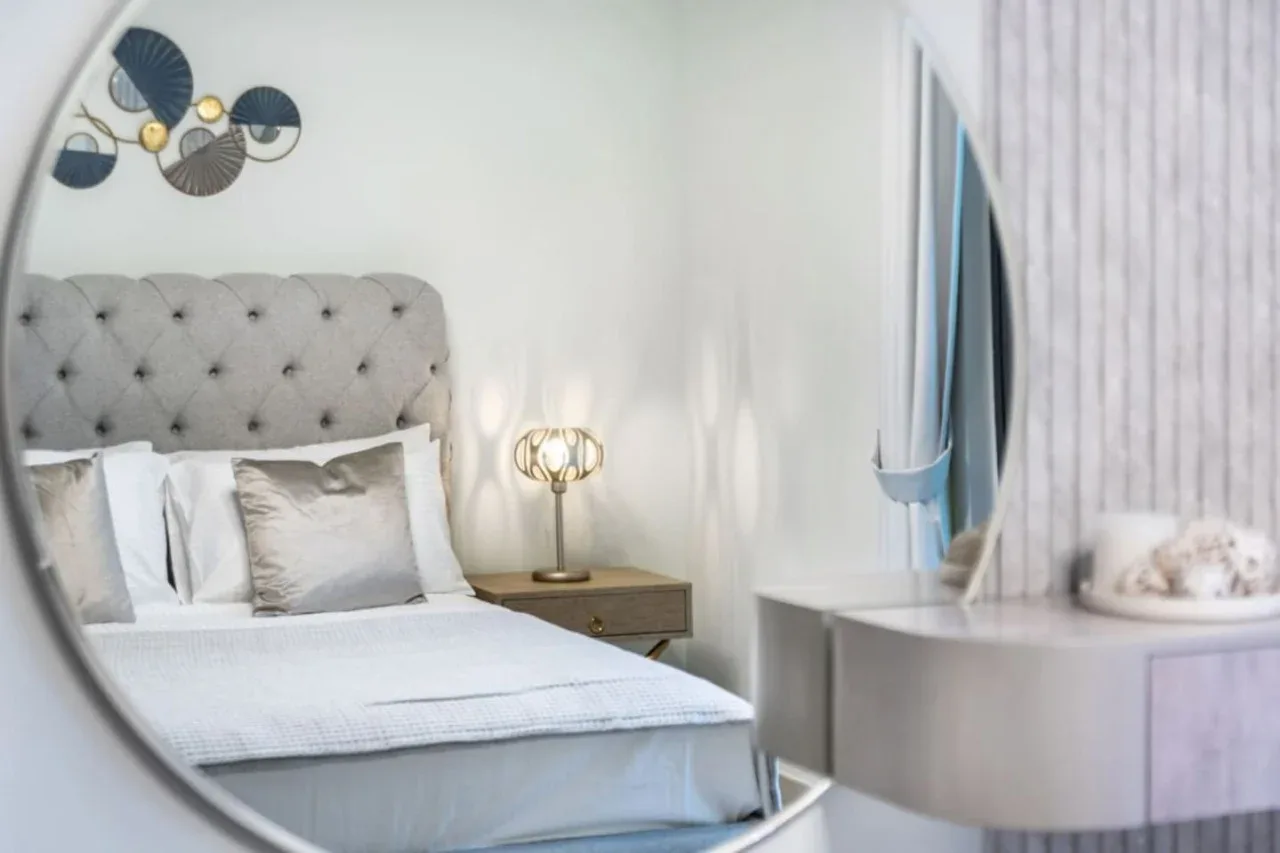Un dormitorio con una cama bien tendida y una mesita de noche.