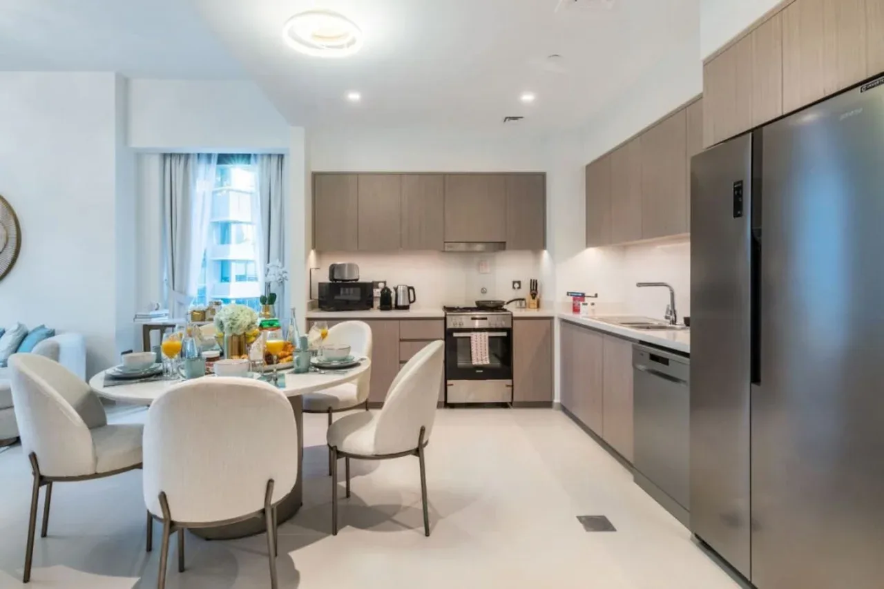 Cocina y comedor de planta abierta con una mesa junto a la ventana.