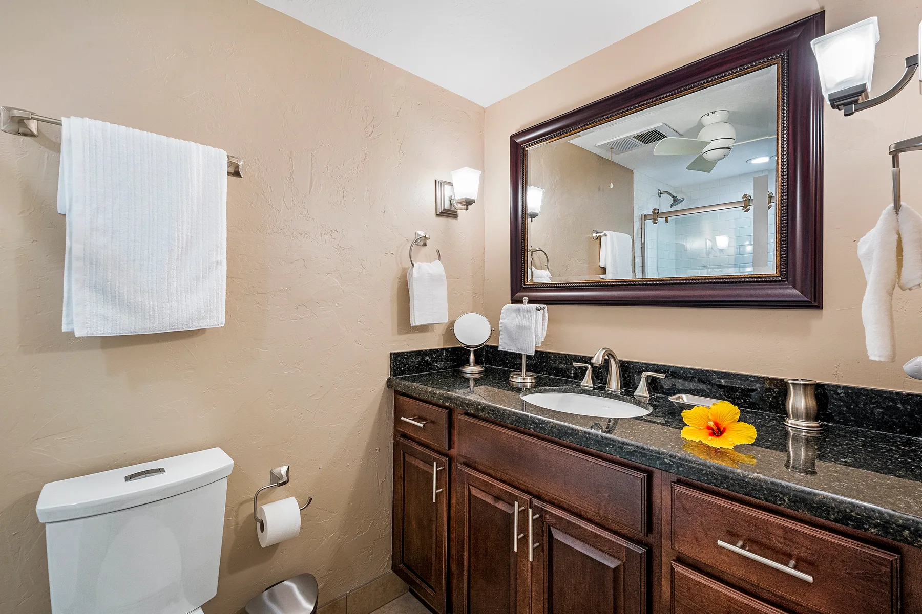 A bathroom vanity with a sink, mirror, and folded towels.