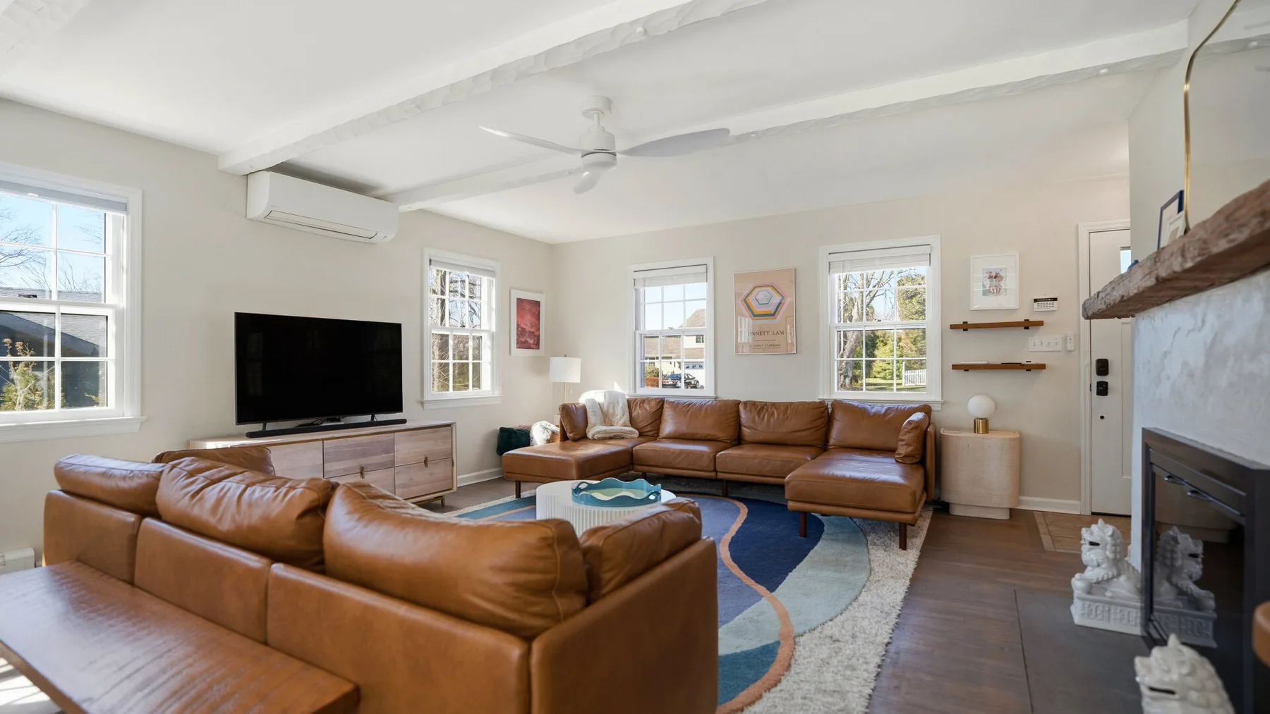 A living room with brown seating arranged around a television and coffee table.
