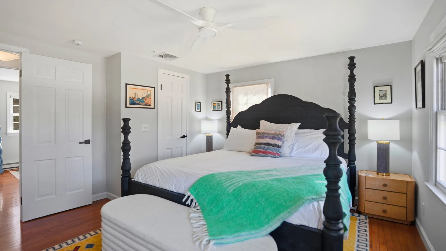 A bedroom with a large bed, bedside tables, and a green throw.