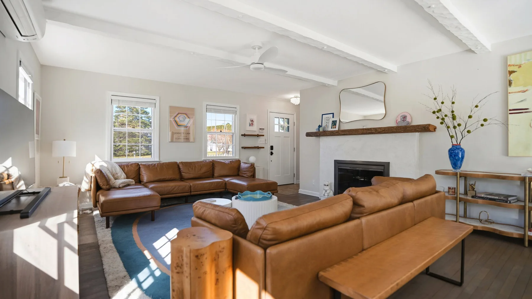 A bright living room with leather seating arranged around a low coffee table.