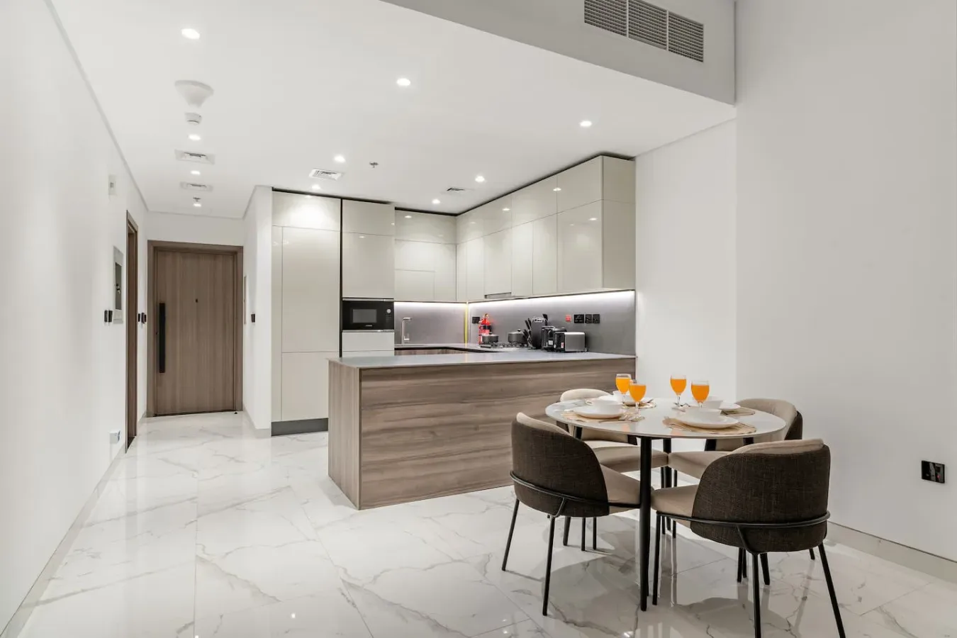 Una cocina moderna con comedor y una mesa junto a la encimera.