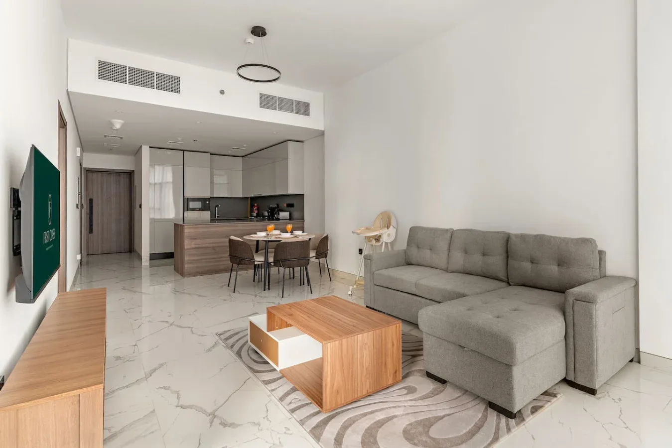 Una sala luminosa con asientos grises y una mesa de centro de madera.