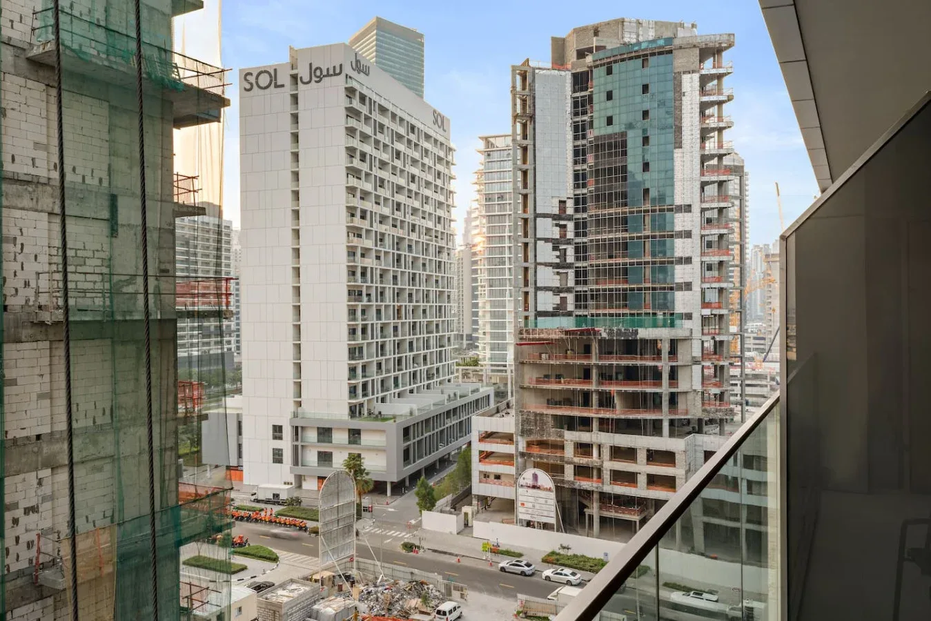 Una calle urbana está rodeada de edificios modernos de gran altura en construcción.
