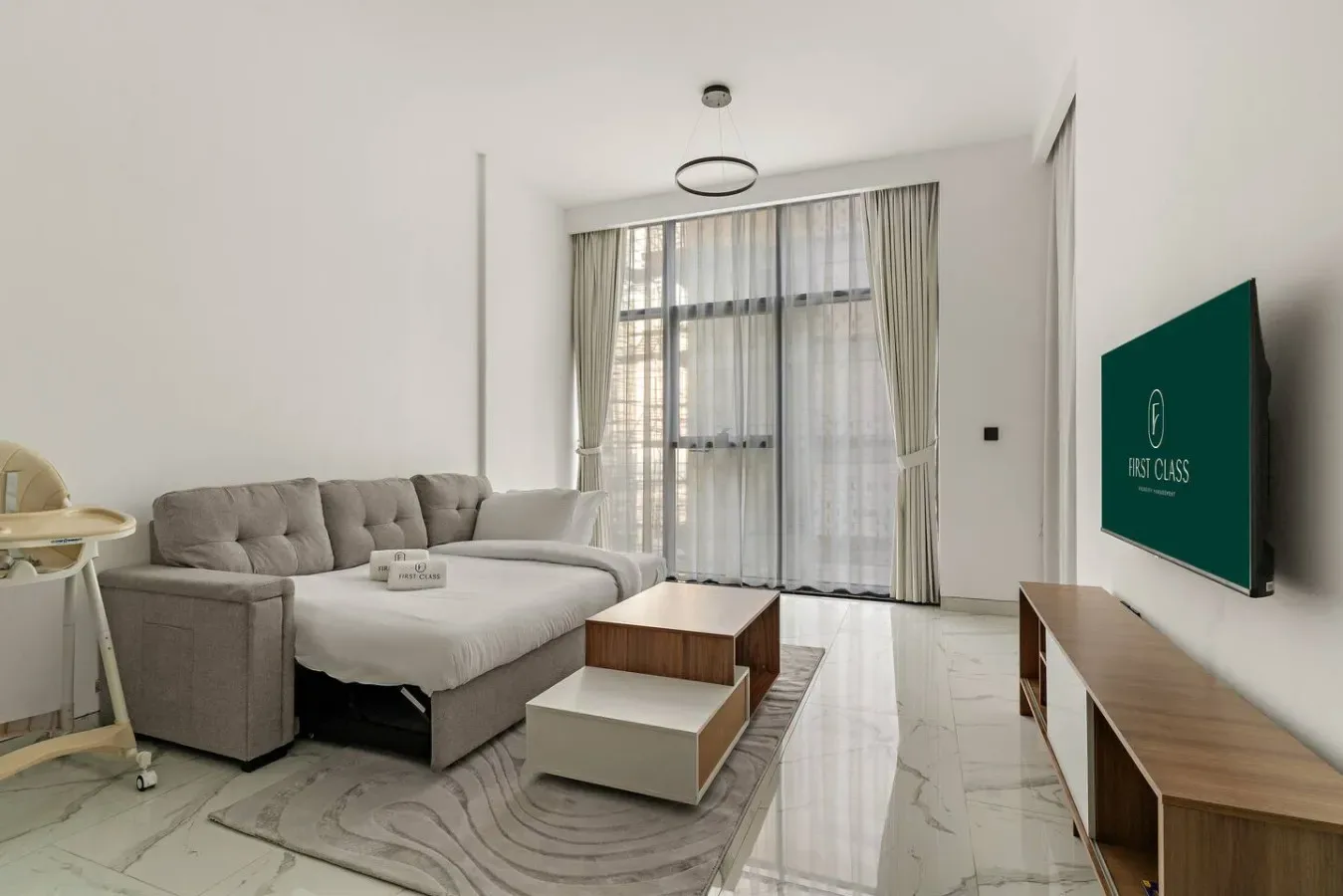 Una sala luminosa con asientos seccionales, una mesa de centro y ventanas altas con cortinas.