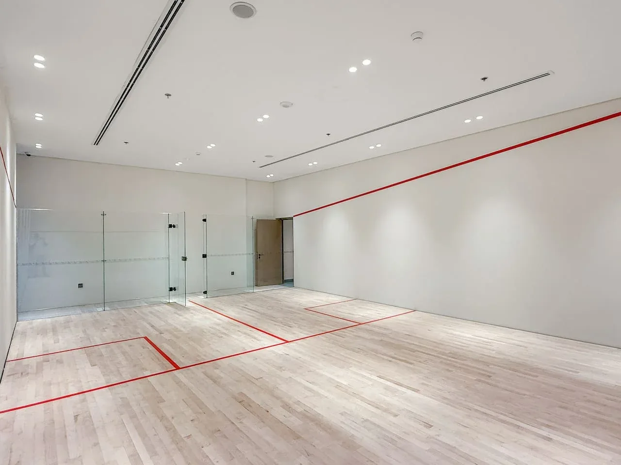 Una cancha interior con líneas rojas y un suelo de color claro.
