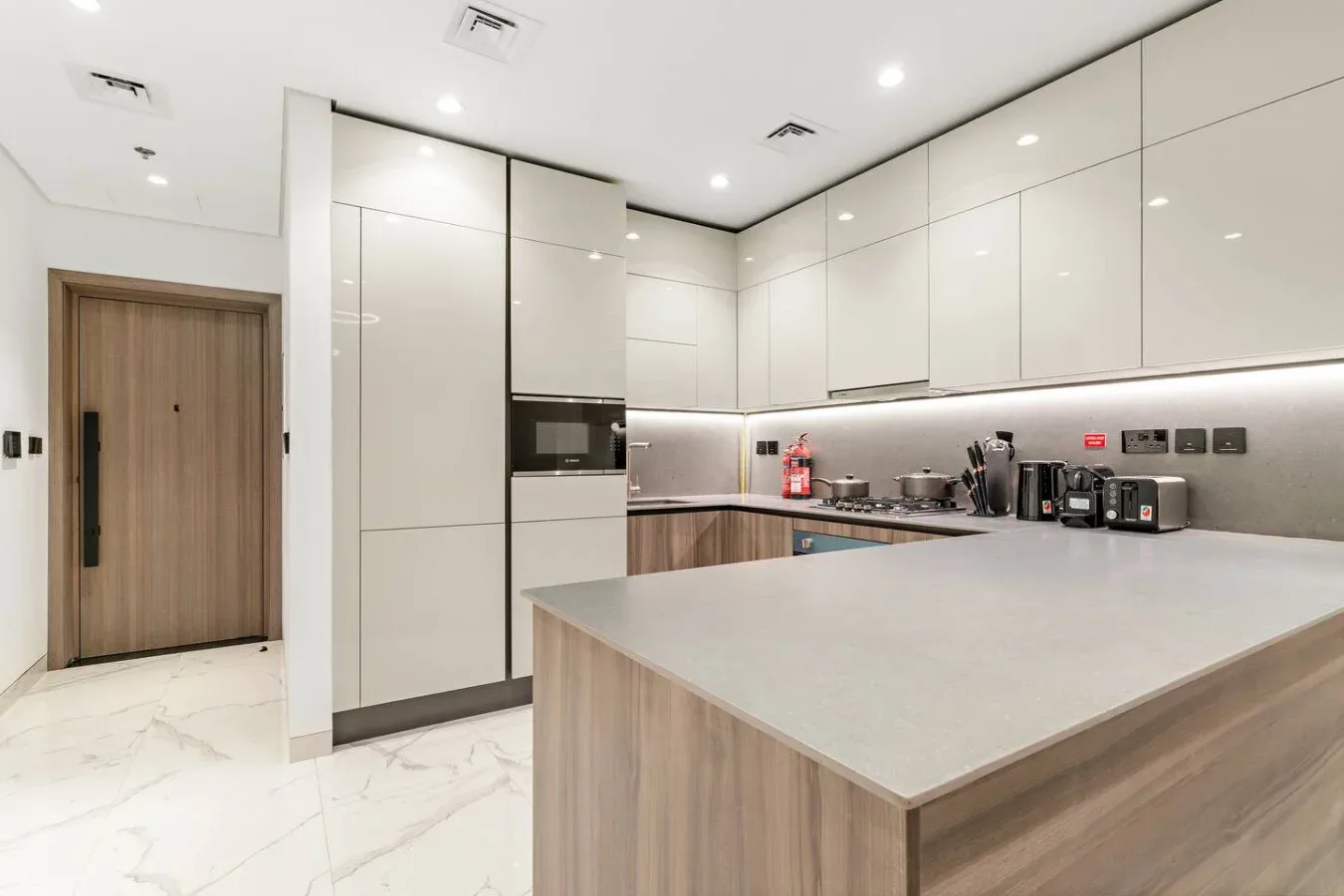 Una cocina moderna con gabinetes blancos y una amplia isla.