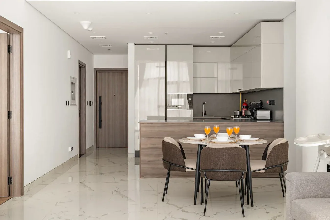 Una cocina moderna y comedor con una mesa puesta con platos y vasos.
