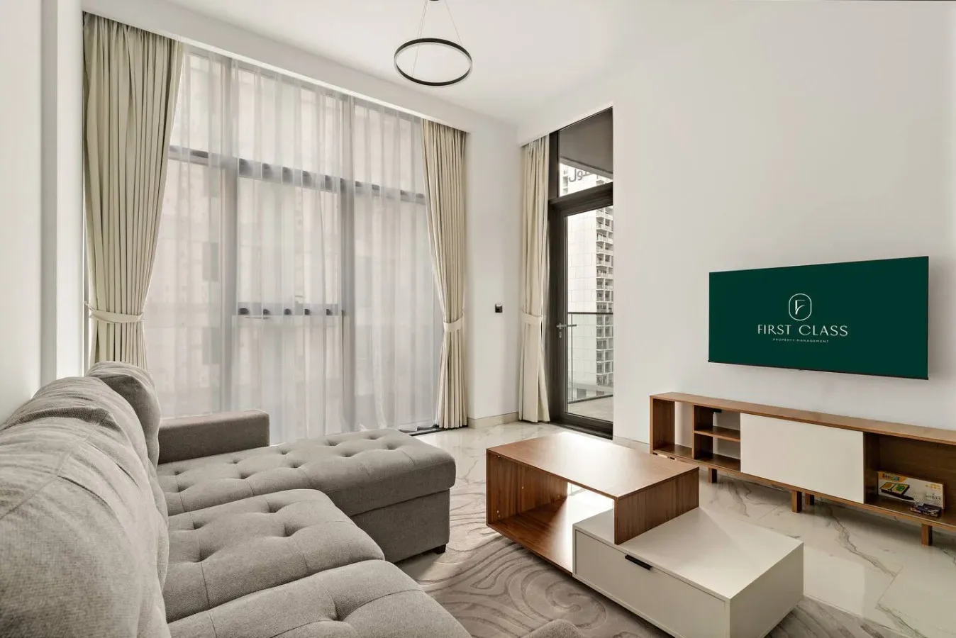 Una sala luminosa con asientos, una mesa de centro y ventanas altas con cortinas.