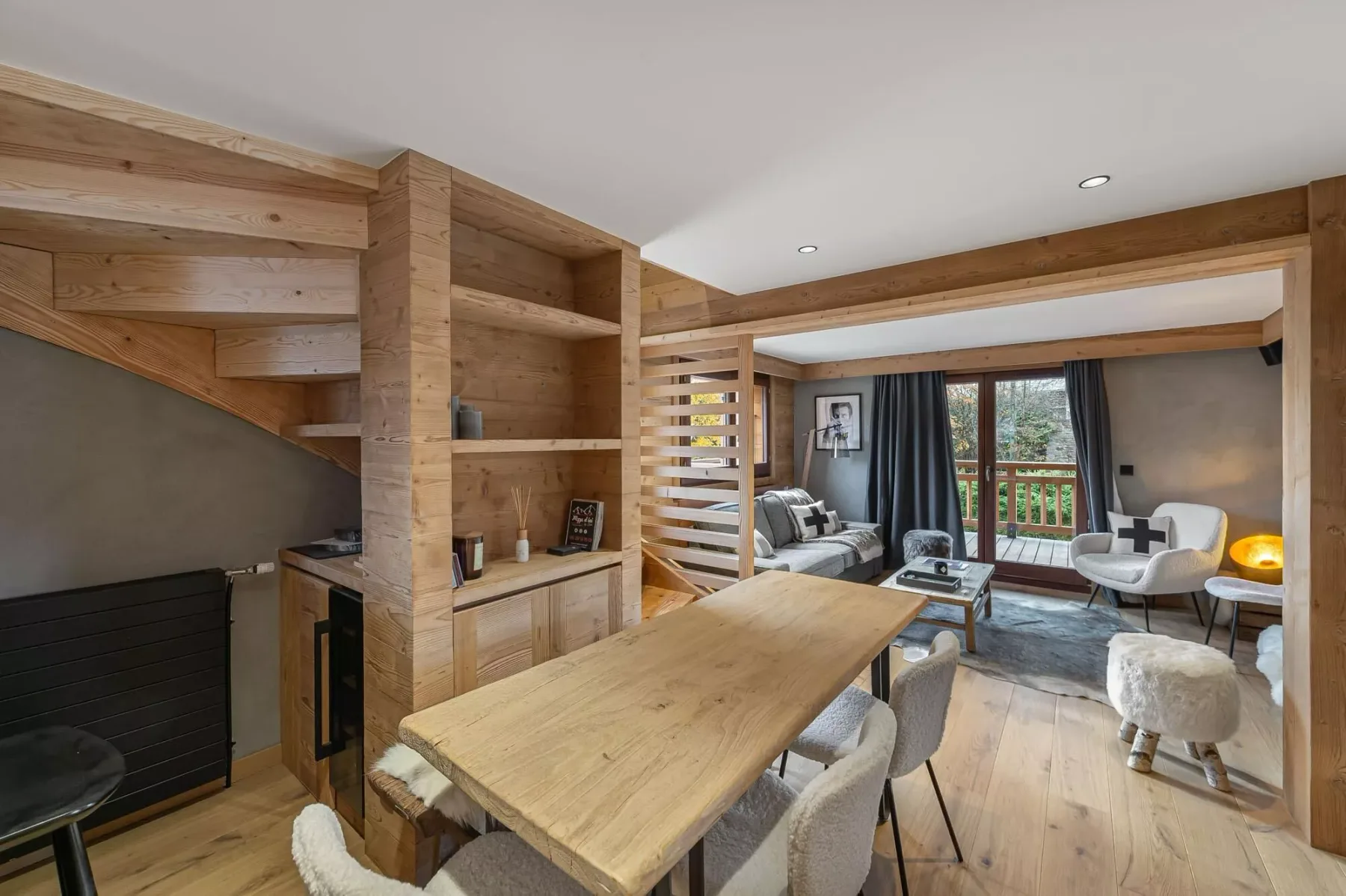 Una sala revestida de madera con mesa de comedor y asientos junto a las ventanas.